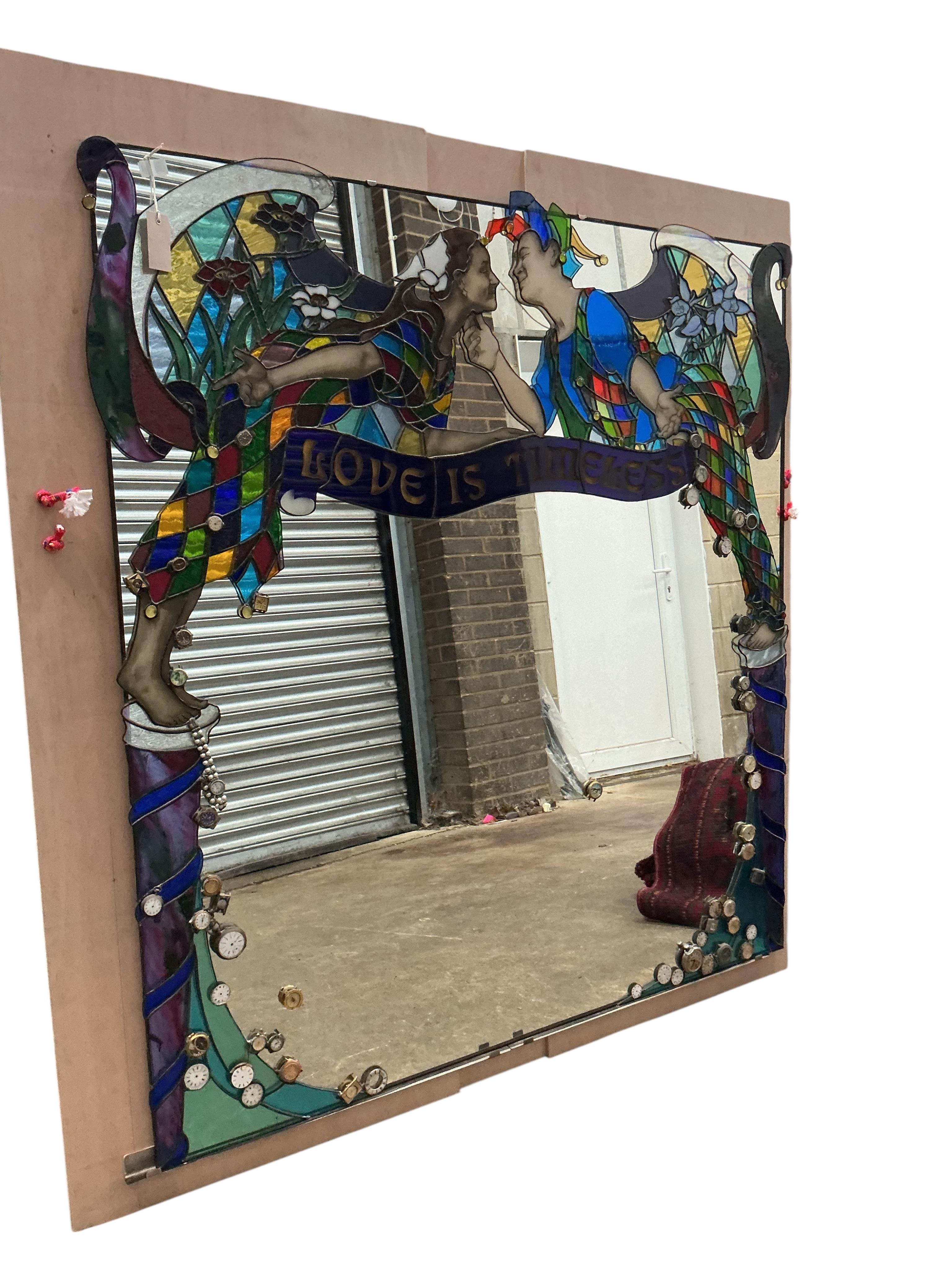 A Contemporary stained glass overmantel mirror “Love is Timeless” by Brighton artist Annelies Clark, the plate inset assorted wristwatch heads, width 128cm, height 138cm
